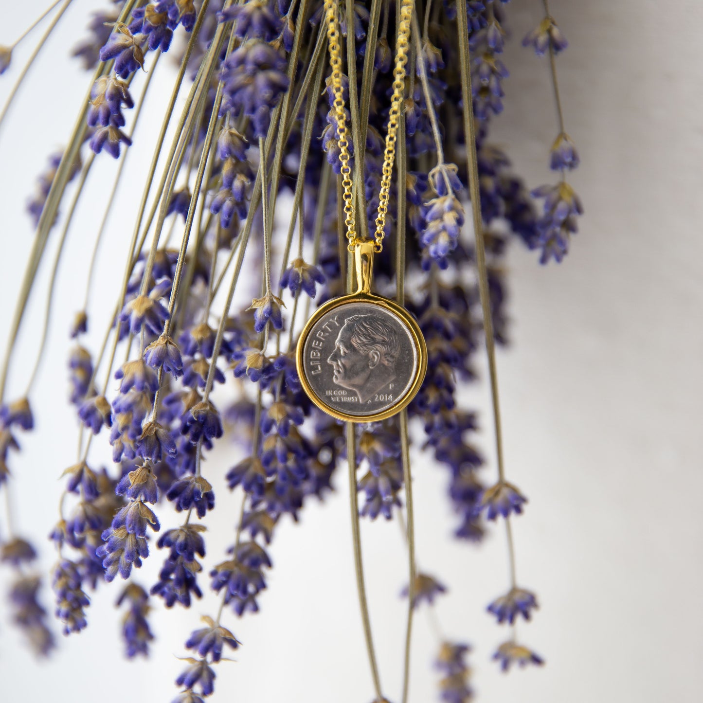 Divine Dime Necklace in gold on lavender